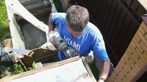A man tightening the bolt with a drill Stock Footage 64776348