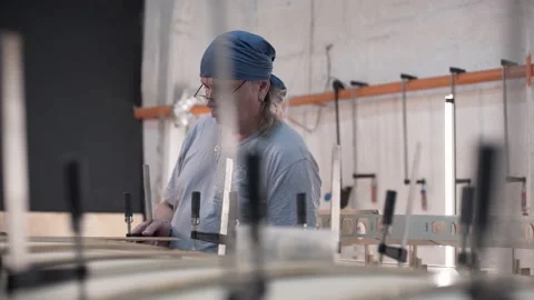 Man tightening the clamp when assembling the Surf Board Stock Footage 132171098