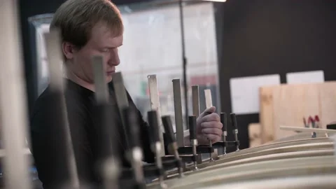 Man tightening the clamp when assembling the Surf Board Stock Footage 132171720