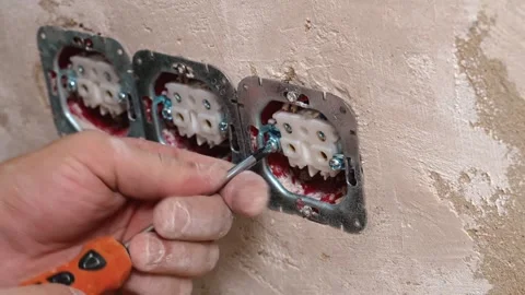 Man Tightening Socket Frame Onto Textured Plaster Wall Carefully Vídeo Stock 329497447