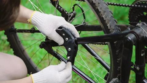 A man tightens the bolts using a hex wrench on the foot of a mountain bike Stock Footage 133913989