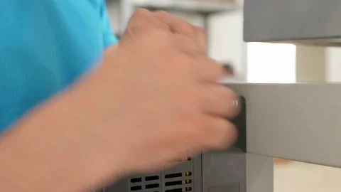 A man tightens a screw on a machine, an angle screwdriver. Stock Footage 204970370