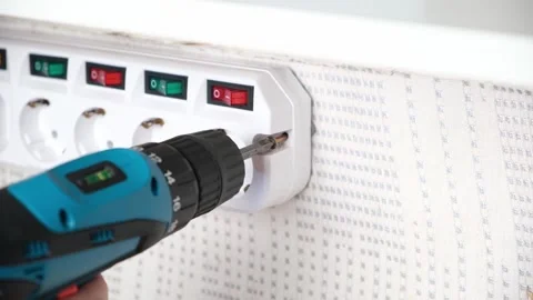 A man tightens a screw with a screwdriver to attach socket adapter with switches Stock Footage 167929378