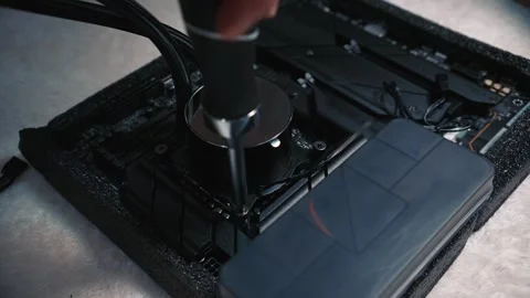 Man tightens water block screw on CPU using screwdriver Stock Footage 324594530