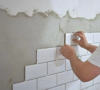 Man tiling the tiles in the kitchen Stock Photos