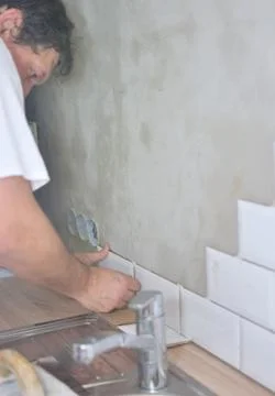 Man tiling the tiles in the kitchen Stock Photos