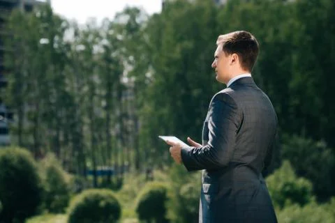A man with tilted jacket suit stands with his back somtrit on the constructio Stock Photos