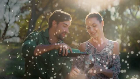 Man tilting bottle, pouring wine into woman sharing glass, bokeh drift over Stock Footage 332642051