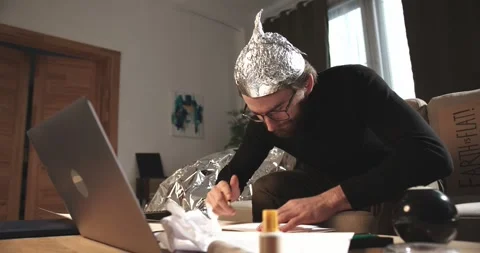 A man in a tinfoil hat draws esoteric signs. Conspiracy theory. Stock Footage 272252755