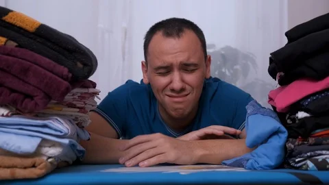Man is tired of Ironing and crying. husband ironing Stock Footage 122861036