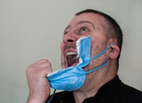 Man tired of wearing the mask rips it off Stock Photos