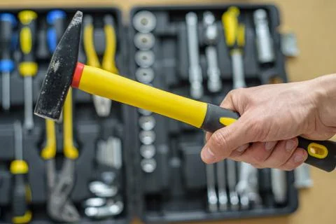 A man took a hammer from a case with tools for work. Close up Stock Photos