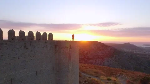 Man on top of a castle on the top of the mountain, watching the sunrise 動画素材 68517658