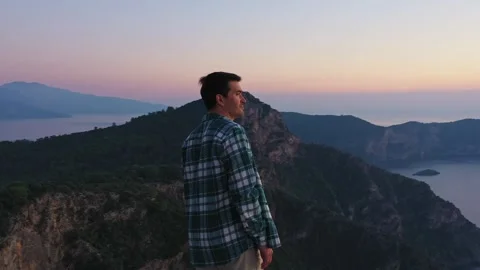 Man on top of the mount enjoying a sunset over  sea Vídeo Stock 306775764