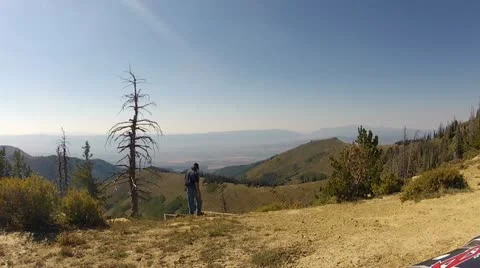 Man on top of mountain ATV ride look at valley HD 009 Stock Footage 11984709