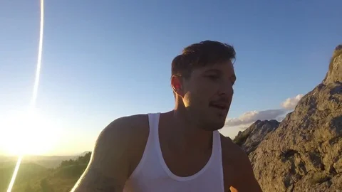 Man on the top of a mountain at sunset Stock Footage 78598411