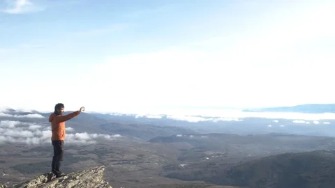 Man on top of the mountain taking a selfie. Adventure and nature concept Stock Footage 123077042