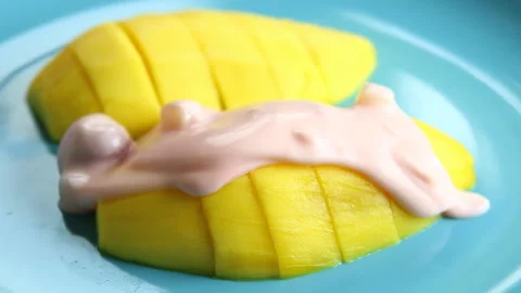 Man is topping mango with yoghurt, in studio Chiangmai Thailand. Stock Footage 185512655