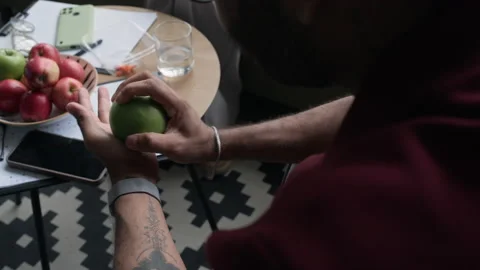 Man Tossing Green Apple during Healthy Snack Break in Office Stock Footage 338338432