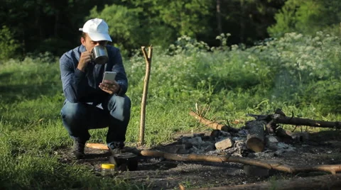 Man touch smartphone in camping with tea Stock Footage 64058097