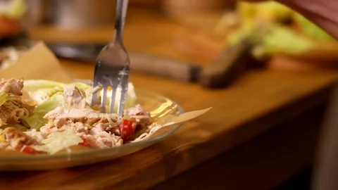 Man touches caesar salad by the fork Stock Footage 76168384