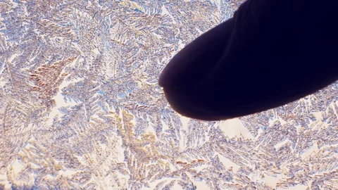 A man touches a glass with an ice pattern with his finger. Ice crystals on the w Stock Footage 122257338
