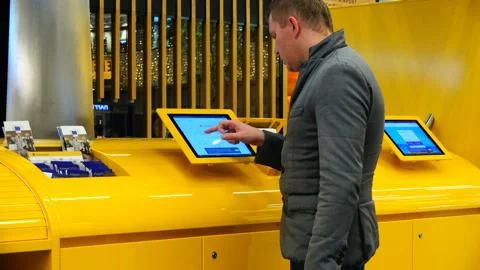 A man touches the touch screen on an electronic device at the airport Stock Footage 92646293
