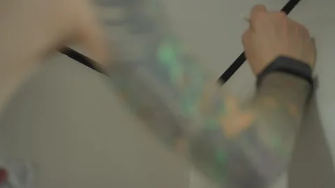 The man is touching up the chips on the wallpaper with a paintbrush. Vídeos de archivo 346547125
