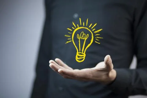 Man touching e light bulb on screen Stock Photos
