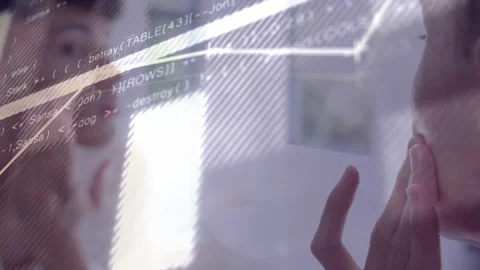 Man touching face shifting gaze at glass display, tech chart and code rising Stock Footage 333689532
