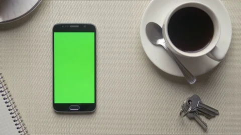 Man touching a green screen of a cell phone put on a desktop Stock Footage 75458236