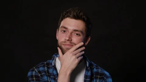 A Man Touching his Beard Against a Black Background Stock Footage 88441655
