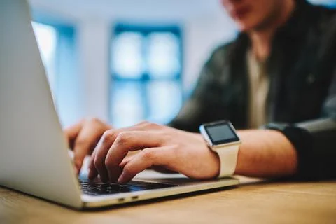 Man touching keyboard of laptop while working Stock Photos