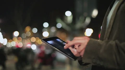 Man touching screen on tablet at night on the street, closeup, steadycam shot Vídeo Stock 37129176