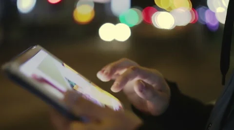 Man touching screen on tablet at night on the street, closeup Stock Footage 57921464