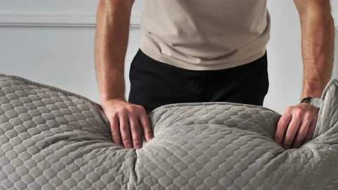 Man touching soft pillows on sofa with his hands. Furniture store Stock Footage 164153925
