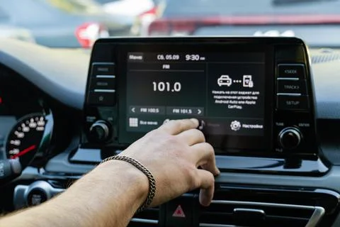Man touching touchscreen dashboard display in modern car Stock Photos