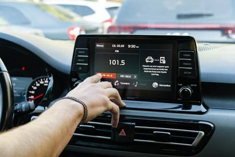 Man touching touchscreen dashboard display in modern car Stock Photos