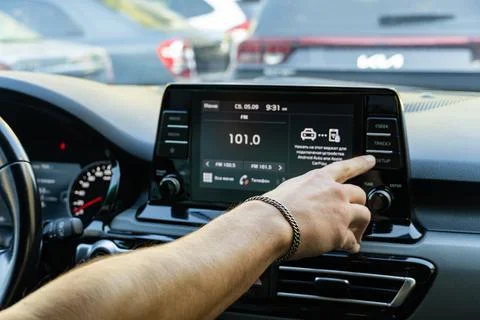 Man touching touchscreen dashboard display in modern car Stock Photos
