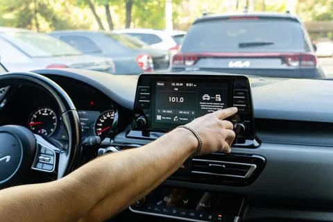 Man touching touchscreen dashboard display in modern car Stock Photos