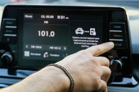 Man touching touchscreen dashboard display in modern car Stock Photos
