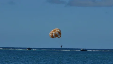 A man touching the water and going up again while practices parasailing Stock Footage 114604327
