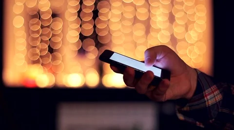 Man with a Touchscreen Mobile Phone on the Beautiful Bokeh Background Video stock 48675813