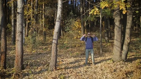 Man tourist with backpack behind, walking through the woods 스톡 동영상 96750647
