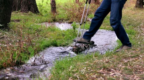 Man tourist with a backpack passes through a stream Stock Footage 56614947