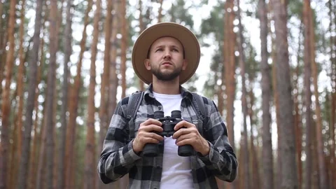 Man tourist with binoculars while hiking in the forest or mountains. Hiking Video stock 149946569