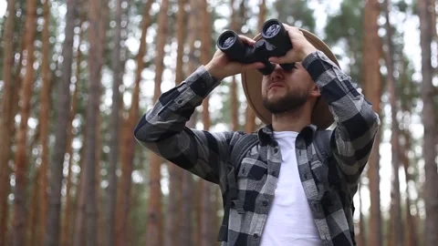 Man tourist with binoculars while hiking in the forest or mountains. Stock Footage 149946580