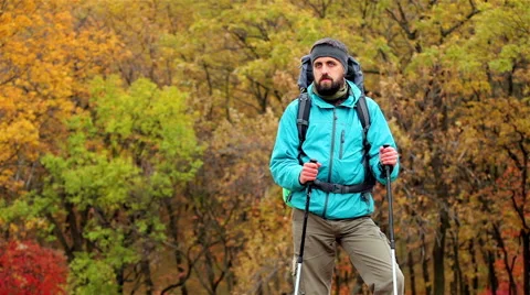 Man tourist in a blue jacket with a backpack looks around Stock Footage 56253558