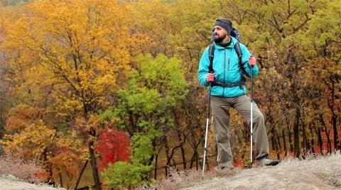 Man tourist in a blue jacket with a backpack looks around Stock Footage 56253645