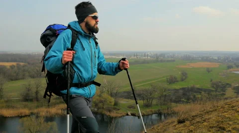 Man tourist in a blue jacket with a backpack looking around Stock Footage 62397480